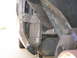 Peel the wheelwell forward to expose the gold T-20 Torx screw, and remove it.