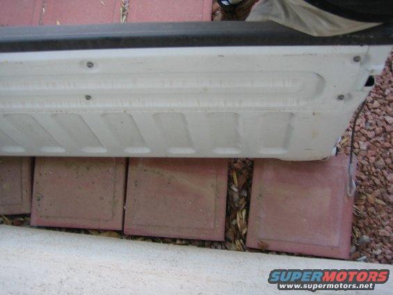 White tailgate step with visible screws