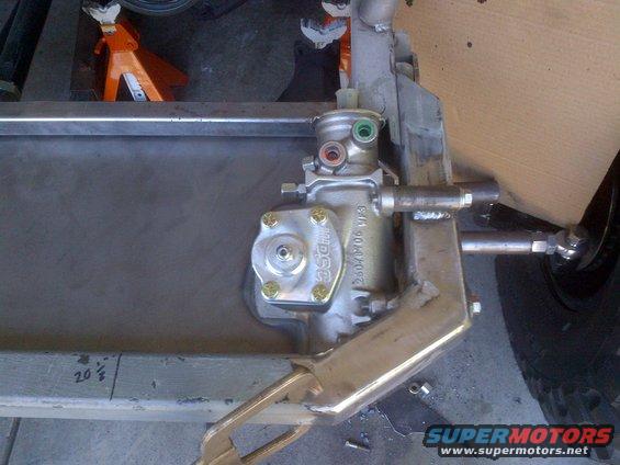 Close-up of a steering box and linkage assembly, possibly for a custom build. Some text is visible on the box