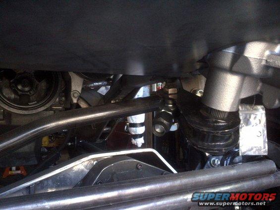 Undercarriage view of steering linkage and suspension components, with a Supermotors watermark