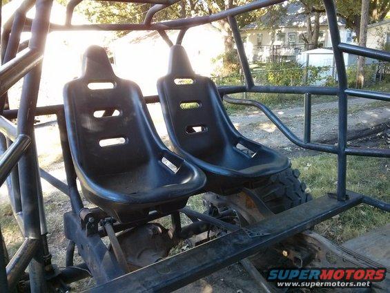 Off-road buggy interior with two black bucket seats and roll cage
