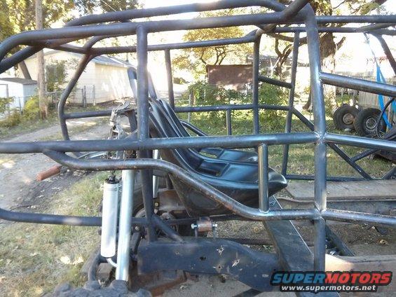 Custom buggy roll cage and seat structure with suspension components visible