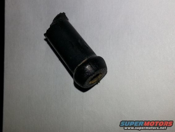 Broken black rubber cylindrical part with a flared end and a hole in the center