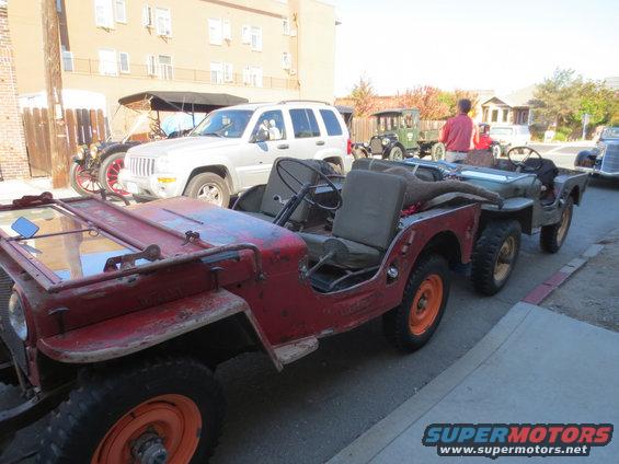 Red 1946 Jeep CJ5 towing another Jeep, side view