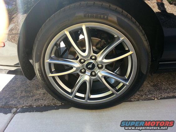 Close-up of a silver 5-spoke wheel with a black Mustang emblem on a Pirelli tire