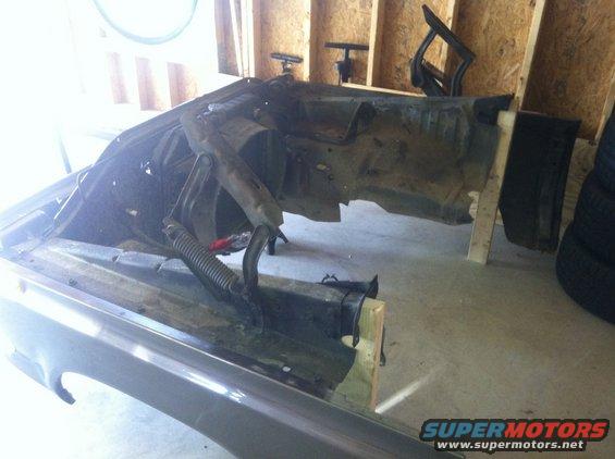 Gray front fender and chassis of a vehicle in a garage