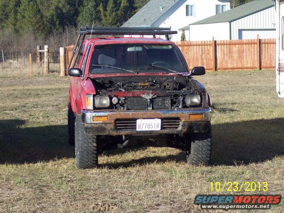red 1991 Toyota Pickup/SR5, hood up, parked in grassy area