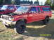 1991 Toyota Pickup/SR5 - A red 1991 Toyota Pickup SR5 is parked outdoors with its hood up, next to another vehicle.