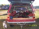 1991 Toyota Pickup/SR5 - Rear view of a red pickup truck loaded with debris, with a dog standing nearby.
