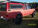 1991 Toyota Pickup/SR5 - Side view of a red 1991 Toyota Pickup/SR5 with a camper shell and roof rack.