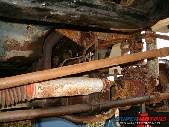 Undercarriage view of rusty suspension components and exhaust system