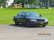 2003 Ford Crown Victoria - A black 2003 Ford Crown Victoria sedan is parked outdoors on a sunny day, with a grassy area and buildings in the background.