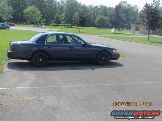Dark 2003 Ford Crown Victoria sedan, side view, parked