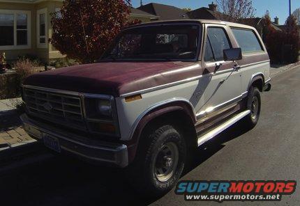 Two-tone maroon and white Ford Bronco parked on a street