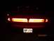 1998 Lincoln Mark VIII - The rear of a car is shown at night, with its brake lights illuminated.