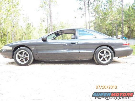 Dark gray coupe with aftermarket wheels parked outdoors