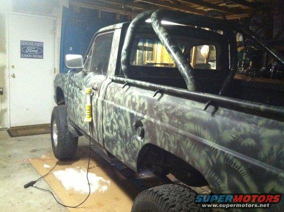 1975 Ford Courier pickup truck with camouflage paint, roll bar, and lifted suspension