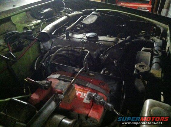 Engine bay with red battery and black engine components