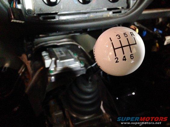 White 6-speed manual shift knob with gear pattern (1, 3, 5, R, 2, 4, 6) in a vehicle interior