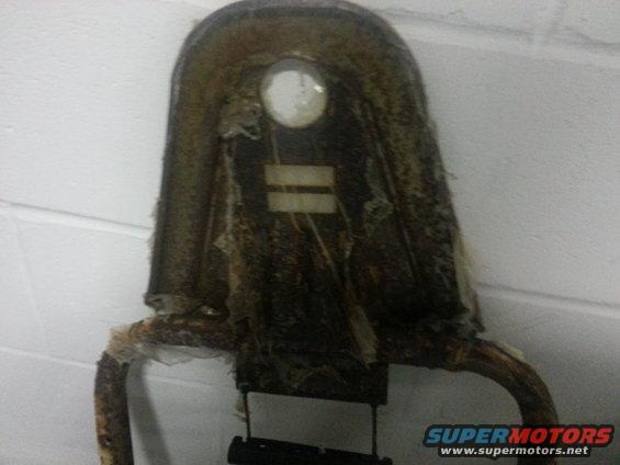 Seat frame with torn upholstery and a circular glass insert