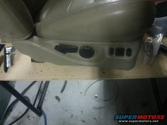 Close-up of a vehicle seat's power adjustment controls and knob