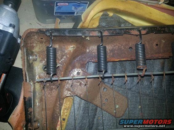 Seat springs and rusted metal frame with orange foam padding