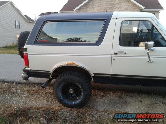 1988 Ford Bronco side view with spare tire on rear door and rust above rear wheel well