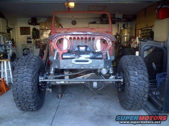 1985 Jeep CJ7 front end in garage, showing winch and large tires