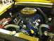 1963 Ford Ranchero - Detailed view of the V8 engine in a yellow 1963 Ford Ranchero, a chrome air cleaner and blue spark plug wires.