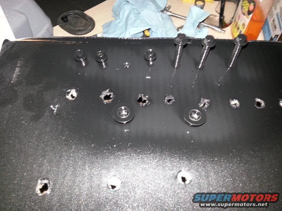 Black part with bolts and holes, SuperMotors logo visible