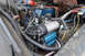 1989 Ford Bronco - Close-up view of an aftermarket air compressor installed in the engine compartment of a vehicle.