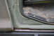 1989 Ford Bronco - Detail of the door jamb and floor area of an older vehicle, showing signs of use.