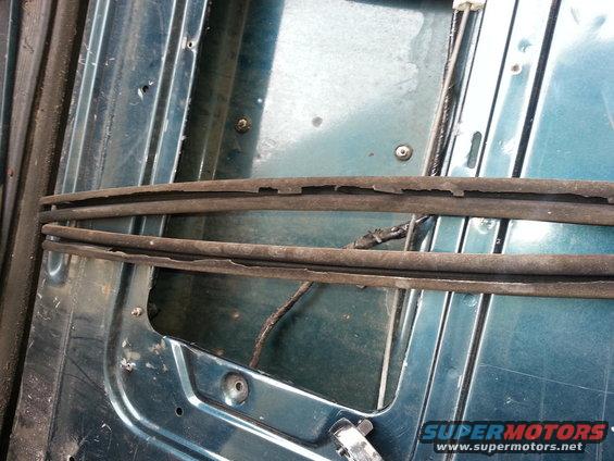 Close-up of two deteriorated rubber seals against a teal metal panel with visible screws and wiring