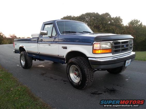 1994 Ford F-250 pickup truck, two-tone blue and white, parked on asphalt