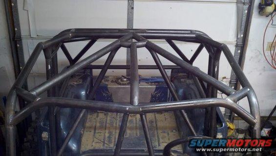 custom roll cage being installed inside a vehicle, showing the interior and fuel tank