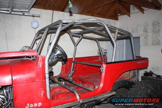 Red Jeep CJ with custom roll cage, side view