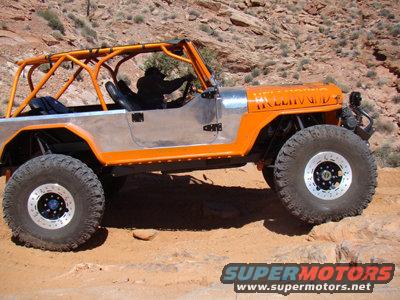 Orange and silver Jeep CJ with roll cage on rocky terrain. Text on hood reads 'HOLLAND'