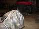 1992 Ford Bronco - A close-up view of a differential housing with visible welding repairs, with a red riding mower in the background.