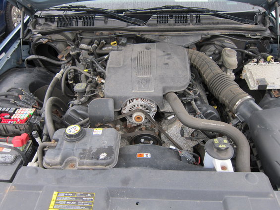 2001 Ford Crown Victoria engine bay with V8 engine, alternator, coolant reservoir, and fuse box visible