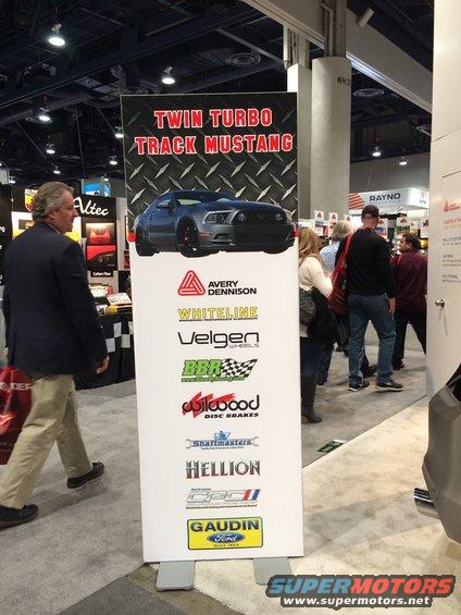 Banner with a blue Ford Mustang graphic and sponsor logos, including Gaudin Ford