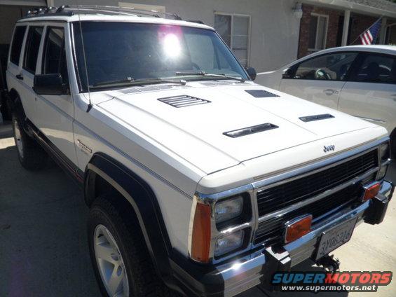 White 1994 Jeep Cherokee with aftermarket hood vents parked outside