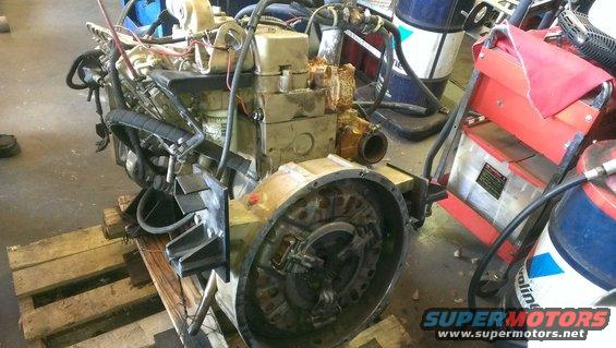 Engine on wooden pallets, with various hoses and mechanical parts visible