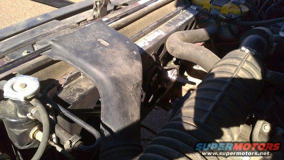 Engine bay with hoses and air intake, dark red exterior paint visible