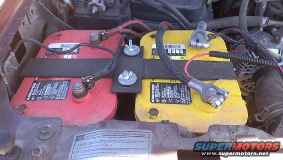 Engine bay with red and yellow Optima batteries. Supermotors.net logo visible