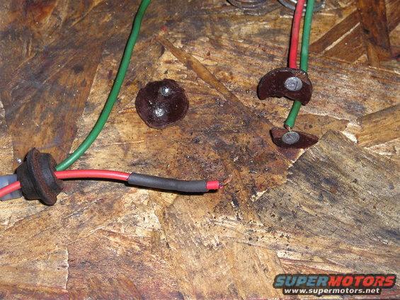 Electrical wiring with red and green wires, heat shrink tubing, and metal connectors on a wooden surface