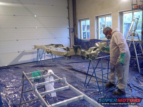 Vehicle frame being painted in a garage