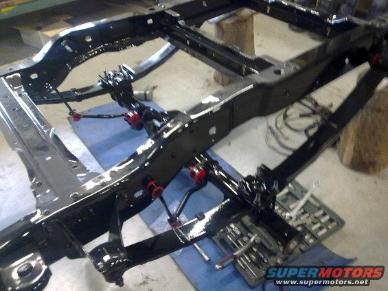 Vehicle frame with suspension parts, red bushings visible