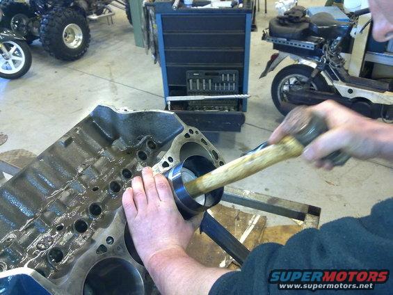 Engine block with piston being installed using a hammer