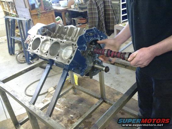 Engine block on stand with camshaft being inserted