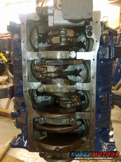 Engine block with crankshaft and connecting rods visible. Some parts are painted blue